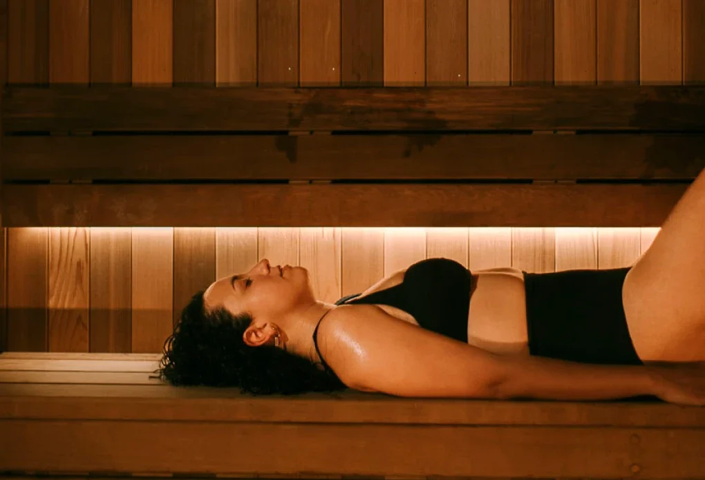 woman lounges in hot nordic sauna at Aurora Spa Bathhouse.