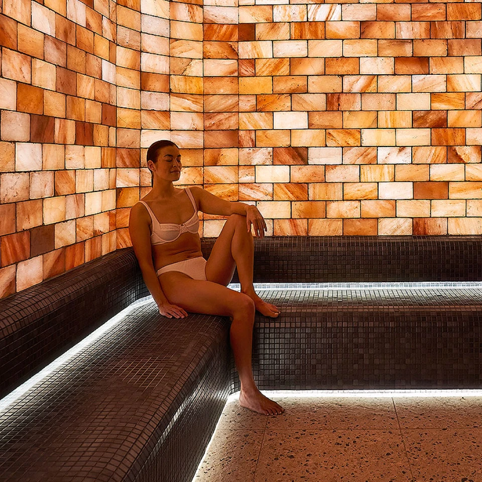 Relaxed woman sitting in the halotherapy (salt therapy) room at Aurora Spa & Bathhouse